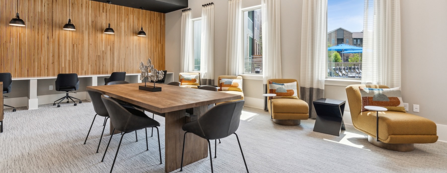 a room with a table, chairs and a large window