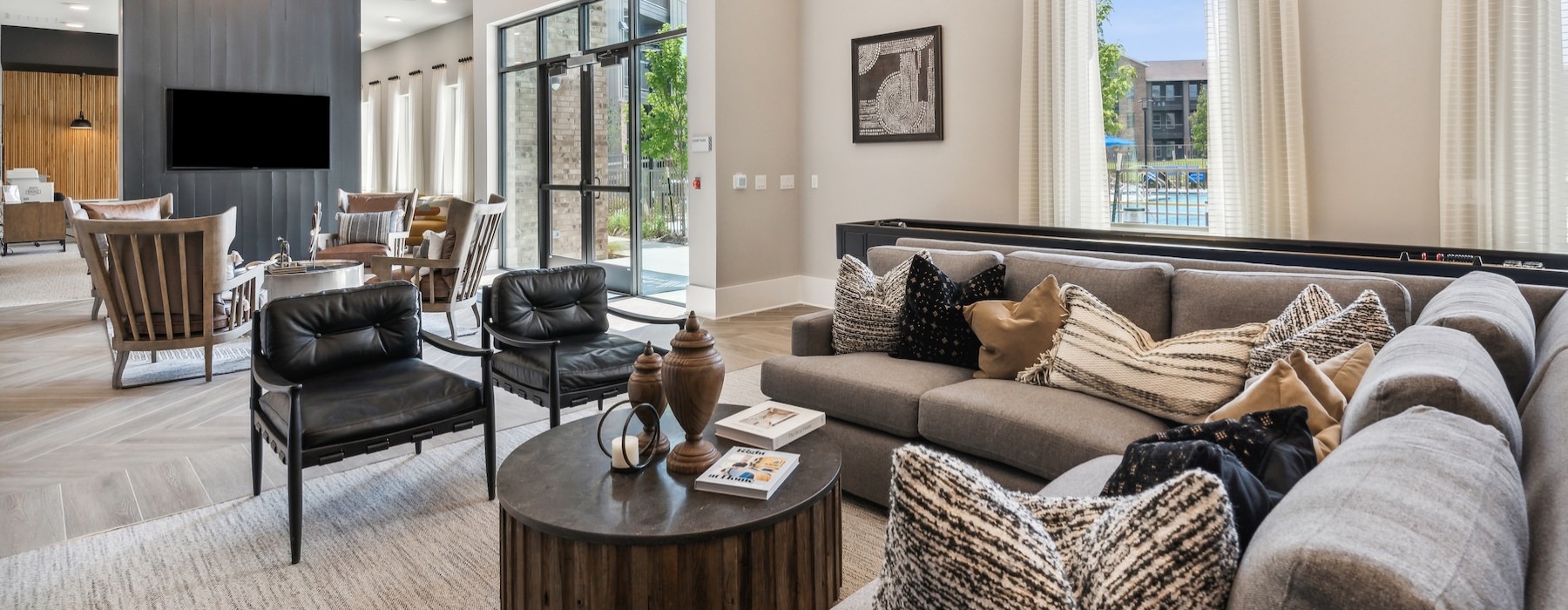 a clubroom with a couch, chairs and tables